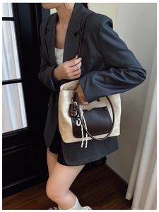 Detail of retro woven tote bag with brown leather pocket and cute chocolate charm