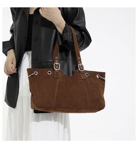 Detail of vintage dark brown suede tote bag featuring metallic eyelets and silver buckles