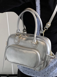 Metallic silver Boston bag with gold hardware and adjustable strap shown on a model