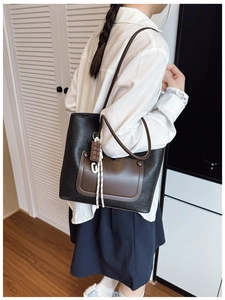Woman wearing stylish large woven tote bag in black and brown for daily commuting style