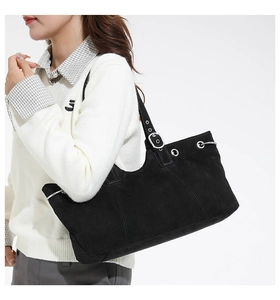 Detail of black matte tote bag with silver eyelets and adjustable shoulder strap