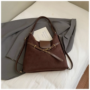 Close-up of dark brown suede tote bag with leather straps and gold metal ring detail