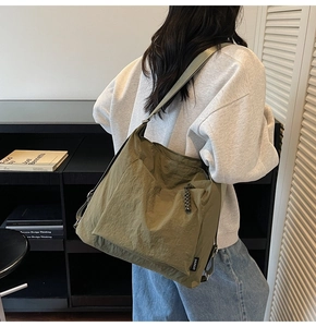 Vue détaillée du grand sac bandoulière vert olive avec étiquette et bandoulière large