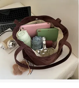 Top-down view of spacious brown velvet tote bag interior holding a tablet and umbrella