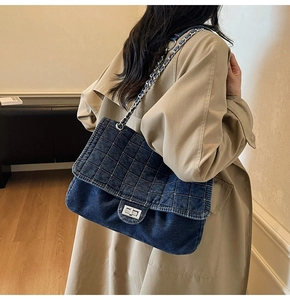 Detail of vintage denim bag featuring quilted stitching and silver metal turn-lock closure