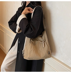 Vue détaillée du sac cabas en nylon kaki avec bandoulière crème et étiquette logo