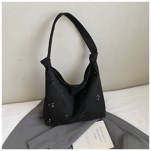 Détails de fleurs découpées au laser et nœud sur ce sac cabas en suédine noire
