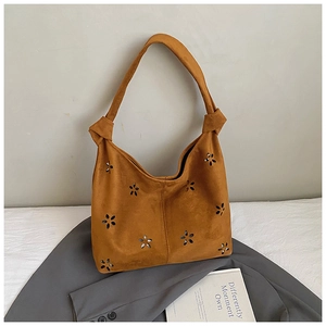 Détail du sac cabas en suède marron avec motifs fleurs ajourées et bandoulière à nœud