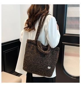 Detail of soft dark brown faux fur tote bag with heart label worn on the shoulder