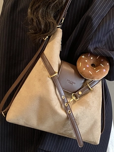 Large khaki suede tote bag with brown leather trim and doughnut charm for stylish commuting