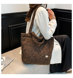 Close-up of brown plush teddy tote bag with silver heart metal buckle detail