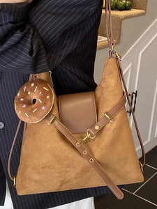 Large suede shoulder bag in caramel brown with adjustable strap and plush donut charm