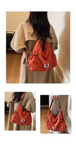 Detail view of the orange canvas bag with bear logo label and adjustable shoulder strap