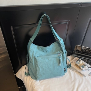 Détail du sac cabas en nylon bleu clair avec texture, boucle métal et tirette tressée