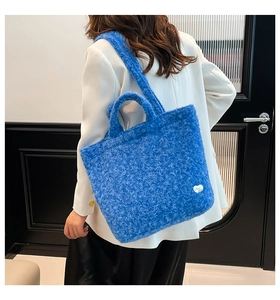 Detail view of sky blue plush tote bag showing the fluffy material and shoulder strap usage