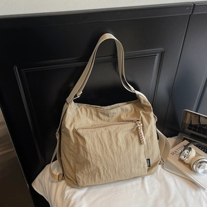 Détail du sac bandoulière kaki montrant la tirette tissée et la boucle en métal