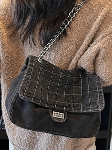 Fashionable black denim chain tote bag with white quilted stitching for women’s daily use