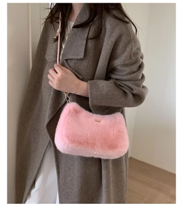 Détail d'un sac à bandoulière en peluche rose avec une texture douce sur un manteau