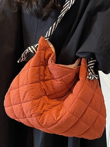 Quilted orange tote bag with black and white rope strap for casual daily use