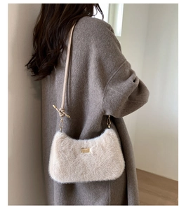 Détail du sac bandoulière en fausse fourrure crème avec zip doré et sangle à nœud
