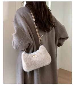 Détail du sac à épaule en peluche beige avec bandoulière tressée et crochets dorés