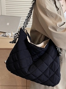 Black quilted tote bag with a striped wide shoulder strap for casual daily commuting