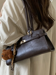 Retro chocolate brown underarm bag with gold lock and plush bear pendant detail