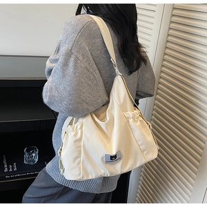 Detail view of the drawstring side and bear logo on a cream canvas tote bag