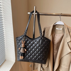 Close-up of black quilted tote bag with houndstooth bunny charm and Fashion Bag logo