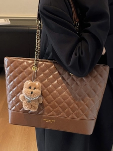 Brown quilted chain tote bag with cute bear charm shown on a fashion model