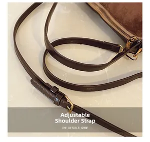 Détail de la bandoulière réglable en cuir marron mat avec boucle en métal doré brillant