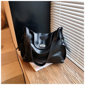 Detail of black large capacity tote bag with silver turn-lock and soft oil wax leather texture