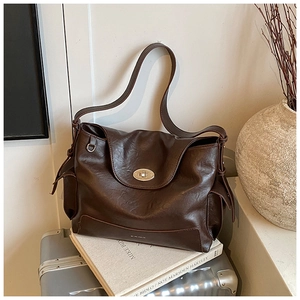 Close-up of vintage brown oil wax leather tote bag with silver twist lock detail