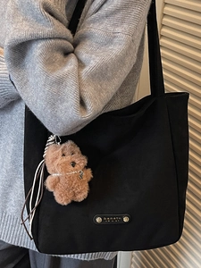 Sac fourre-tout noir minimaliste avec breloque ours en peluche et étiquette en cuir