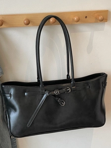 Minimalist black faux leather tote bag with stylish belt buckle detail for women