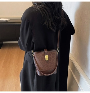 Detailed close-up of dark brown leopard print bucket bag with smooth leather finish