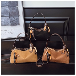 Gros plan des sacs en daim patchwork rétro avec glands en perles boho et boucles dorées