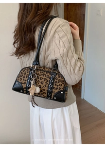 Detail of retro leopard print Boston bag with black leather trim and sports charms