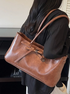 Minimalist brown faux leather tote bag with metallic buckle and spacious interior