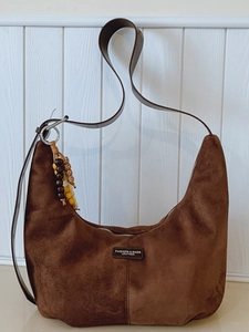 Brown faux suede hobo bag with moon shape and beaded charm for daily commuting style