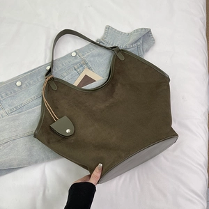 Détail d'un grand sac cabas vintage en daim marron avec bandoulière et pochette décorative