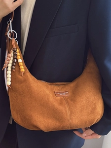 Brown suede crescent hobo bag with wooden beads decoration and half-moon silhouette