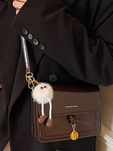 Brown glossy leather crossbody bag with chain and cute plush doll pendant accessory