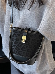 Chic leopard print bucket tote bag with gold buckle and adjustable strap shown on model