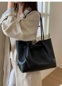Close-up of textured black leather tote bag with stylish drawstring knots on model