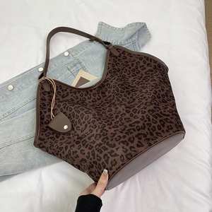 Vue détaillée du sac cabas à imprimé léopard marron avec garniture en cuir et pendentif