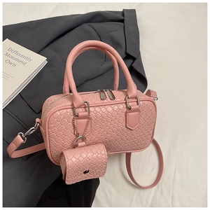 Detail of pink woven leather satchel with matching mini charm bag and silver hardware