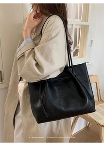 Close-up of black tote bag with textured faux leather and drawstring details