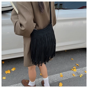Détail montrant les longues franges d'un sac hobo bandoulière noir en cuir mat