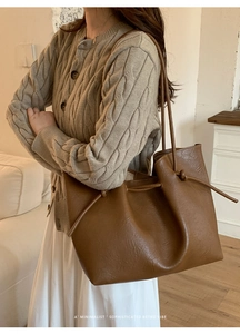 Close-up of brown pebbled leather tote bag with retro drawstring side detail